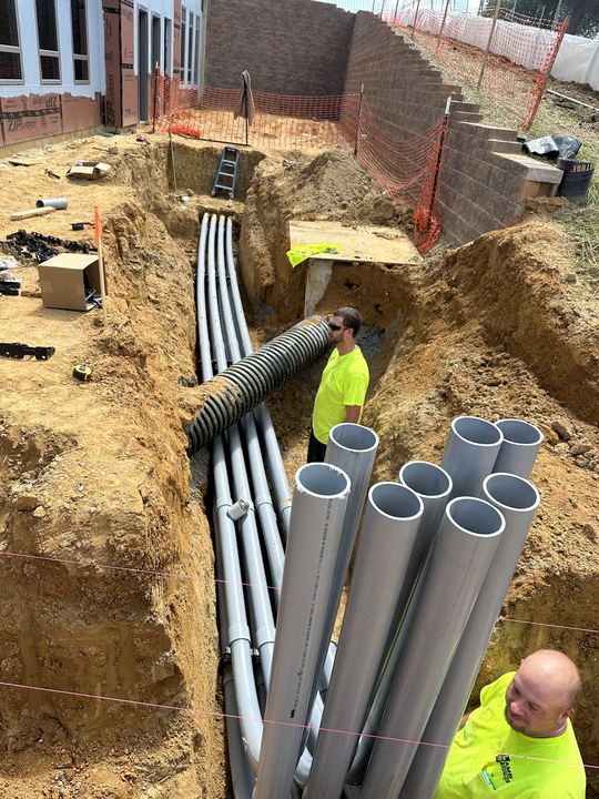 Electrician installing multiple underground conduits